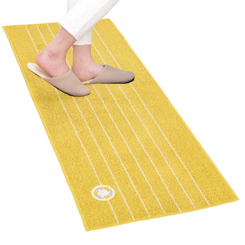 キッチンマット　リース　45×120cm　イエロー 明るいイエローの模様が施された、横長のマットが広がる様子