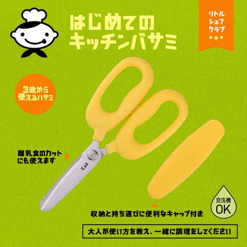 はじめてのキッチンバサミ　リトルシェフクラブ 持ち手部分が強調された、鮮やかな色合いのキッチンバサミがテーブルに置かれている状況。