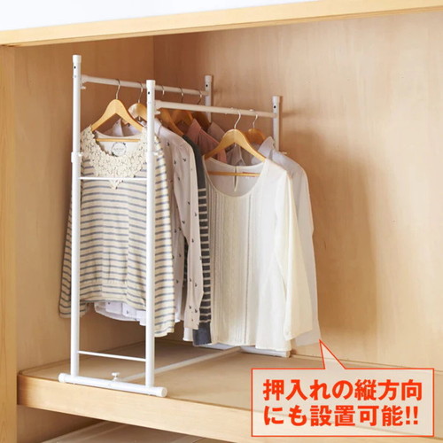 押入れ収納 伸縮押入れ2連ハンガー ハンガーラック シンプルなデザインのハンガーが壁に取り付けられ、衣類がかけられた状態