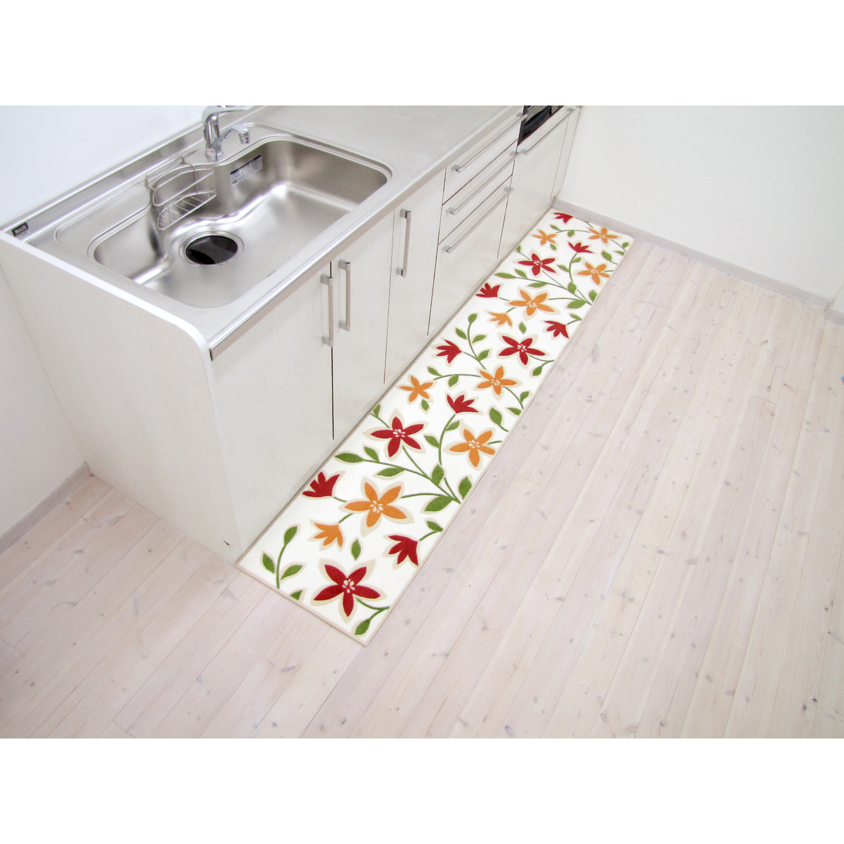 オカ パッションフラワー キッチンマット BE 45x240 鮮やかな花柄がデザインされたキッチンマットの全景、穏やかなベージュ地に映えるパターンが特徴的。