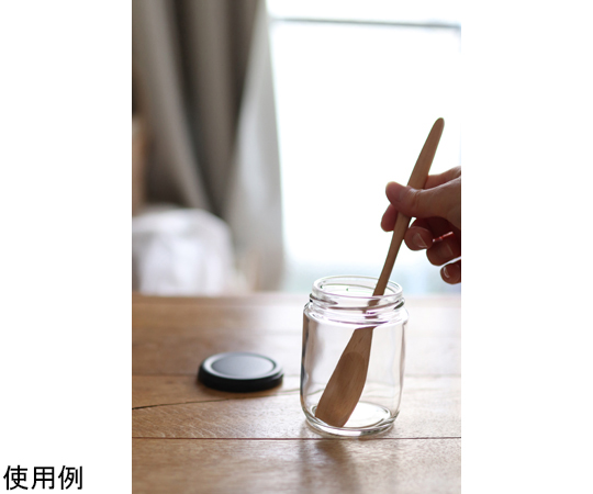 すくいやすい ハニースプーン 透明なプラスチック製のスプーンが明るい背景で横向きに置かれ、先端に蜂蜜がのっています。