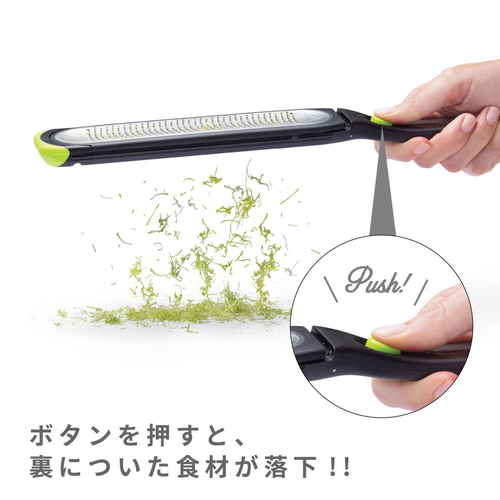 dreamfarm　Ozest　グレーター シンプルなデザインのグレーターが横向きで置かれ、ステンレスの刃が光を反射している様子。