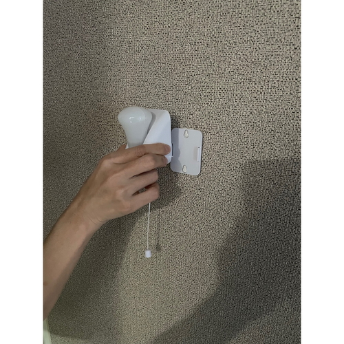 電池式ひも引きライト 明るい光を放つ底部に鈴の付いた引き紐が見える状態