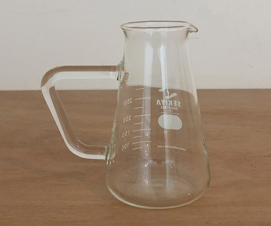 取っ手付きコニカルビーカー 300ml 透明な容器に液体が注がれ、取っ手が側面に付いている状態