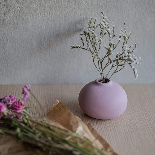 花瓶　AYA　フラワーベース　ラウンド　PU　パープル 丸みのあるデザインのパープル色のフラワーベースがテーブルの上に置かれた様子