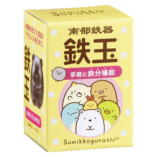 南部鉄玉　すみっコぐらし 丸い形状の黒い茶釜がテーブルに置かれ、柔らかな光が当たっている様子